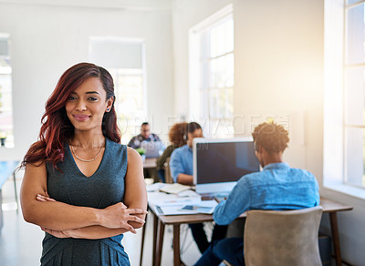 Buy stock photo Portrait of a confident young woman working a modern office with her team in the background