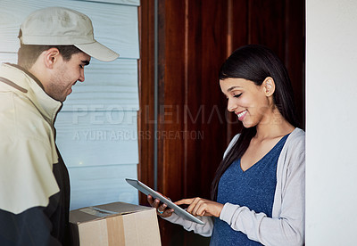Buy stock photo Cropped shot of a young woman using a digital tablet to sign for her delivery from the courier