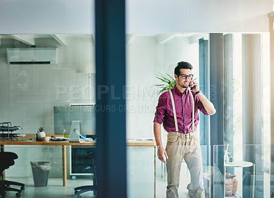 Buy stock photo Cropped shot of a handsome young designer talking on his cellphone in the office