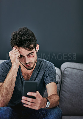 Buy stock photo Cropped shot of a beaten and bruised young man reading a text message