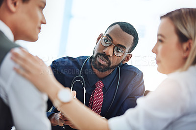 Buy stock photo Cropped shot of a young couple having a consultation with their doctor