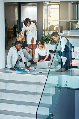 Buy stock photo Shot of a group of coworkers working together while gathered on the floor