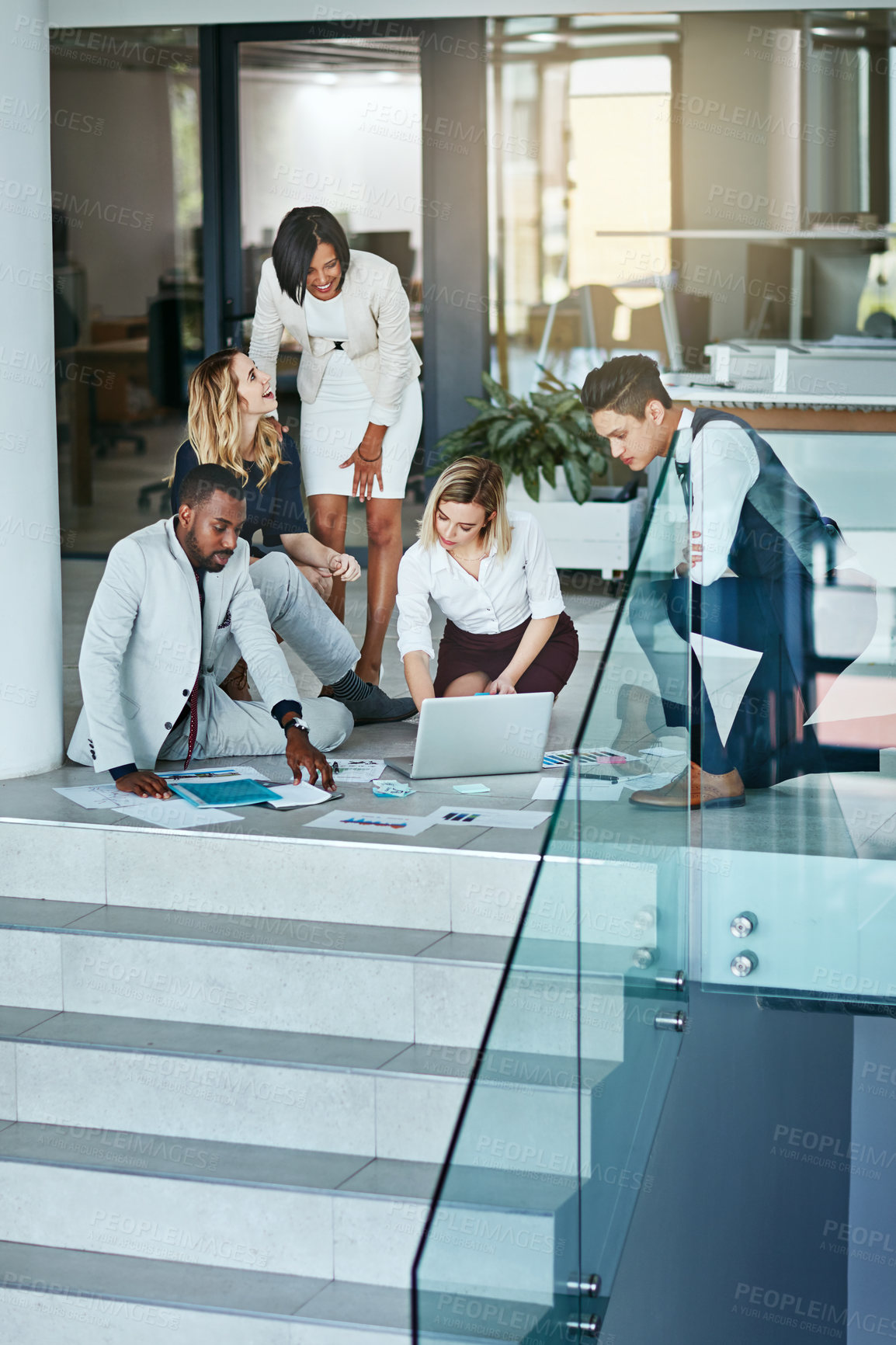 Buy stock photo Shot of a group of coworkers working together while gathered on the floor