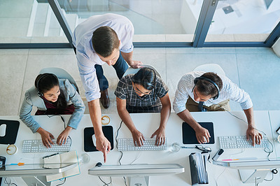 Buy stock photo High angle shot of a man assisting his colleagues in a call center