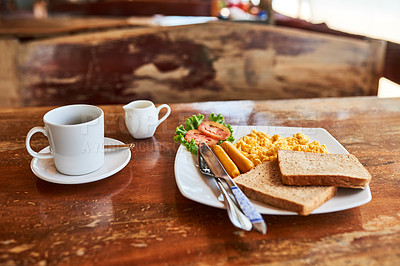 Buy stock photo Shot of a cup of coffee and freshly made breakfast on a table