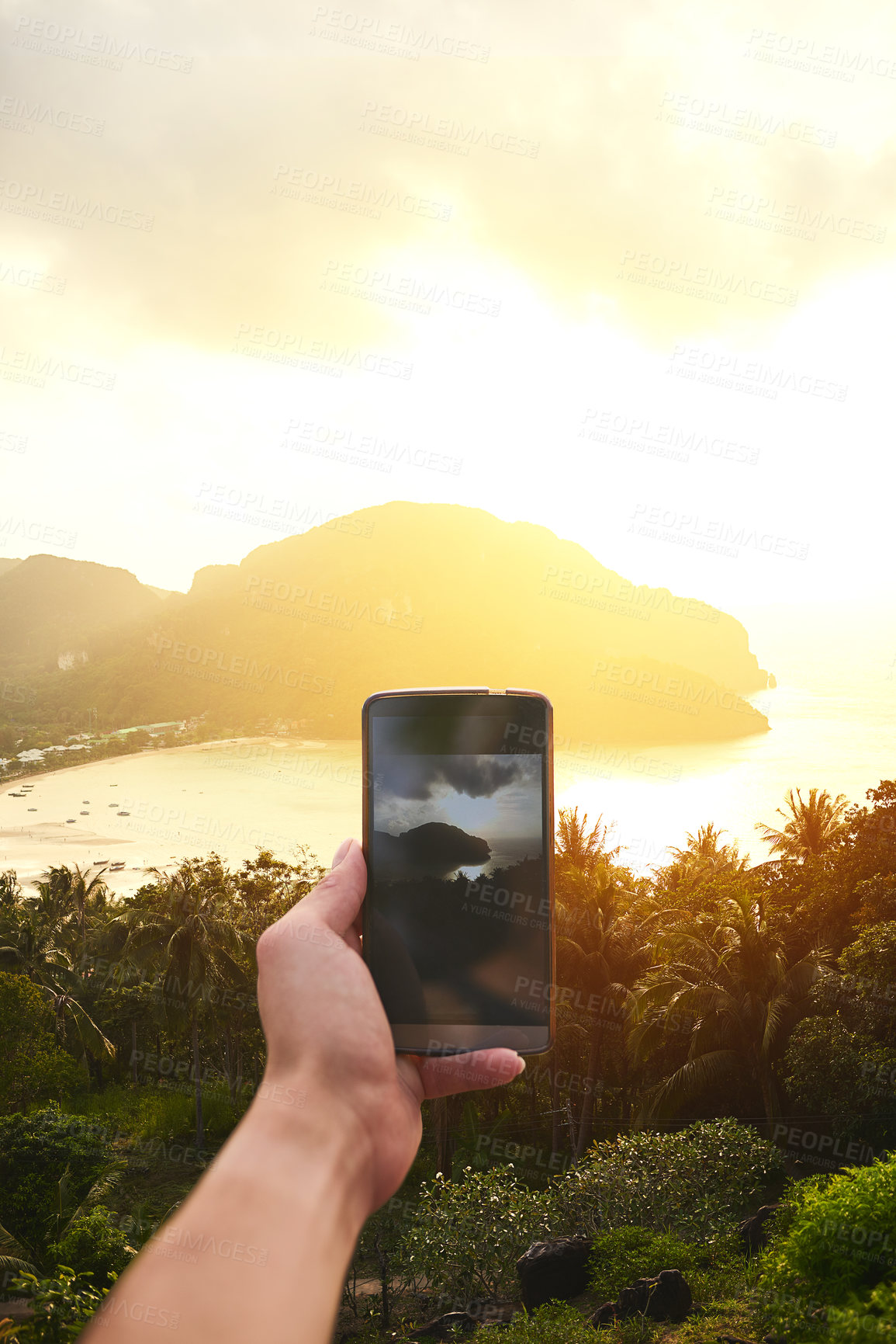 Buy stock photo Cropped shot of an unidentifiable tourist using a smartphone to photograph an island view