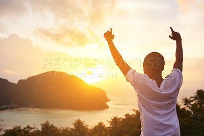 Buy stock photo Rearview shot of a young tourist raising his arms against a sunset view