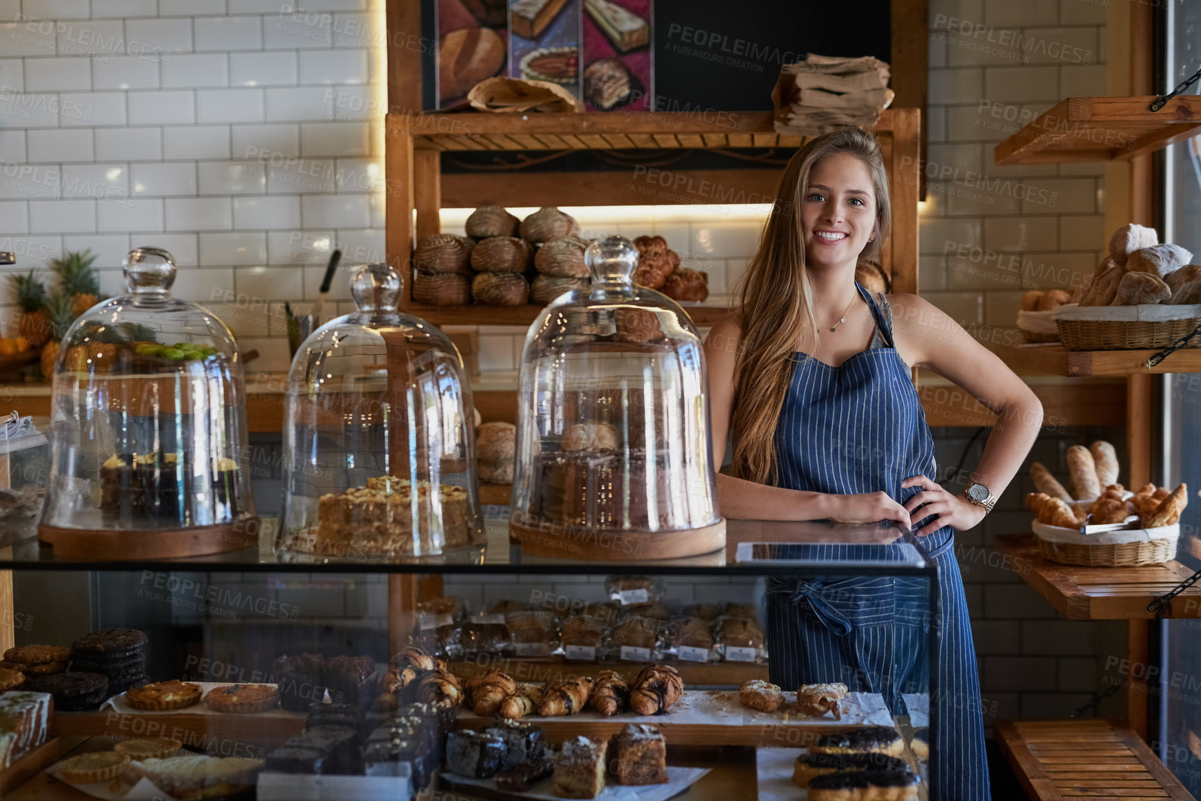 Buy stock photo Portrait of a young business owner standing behind the counter of her bakery