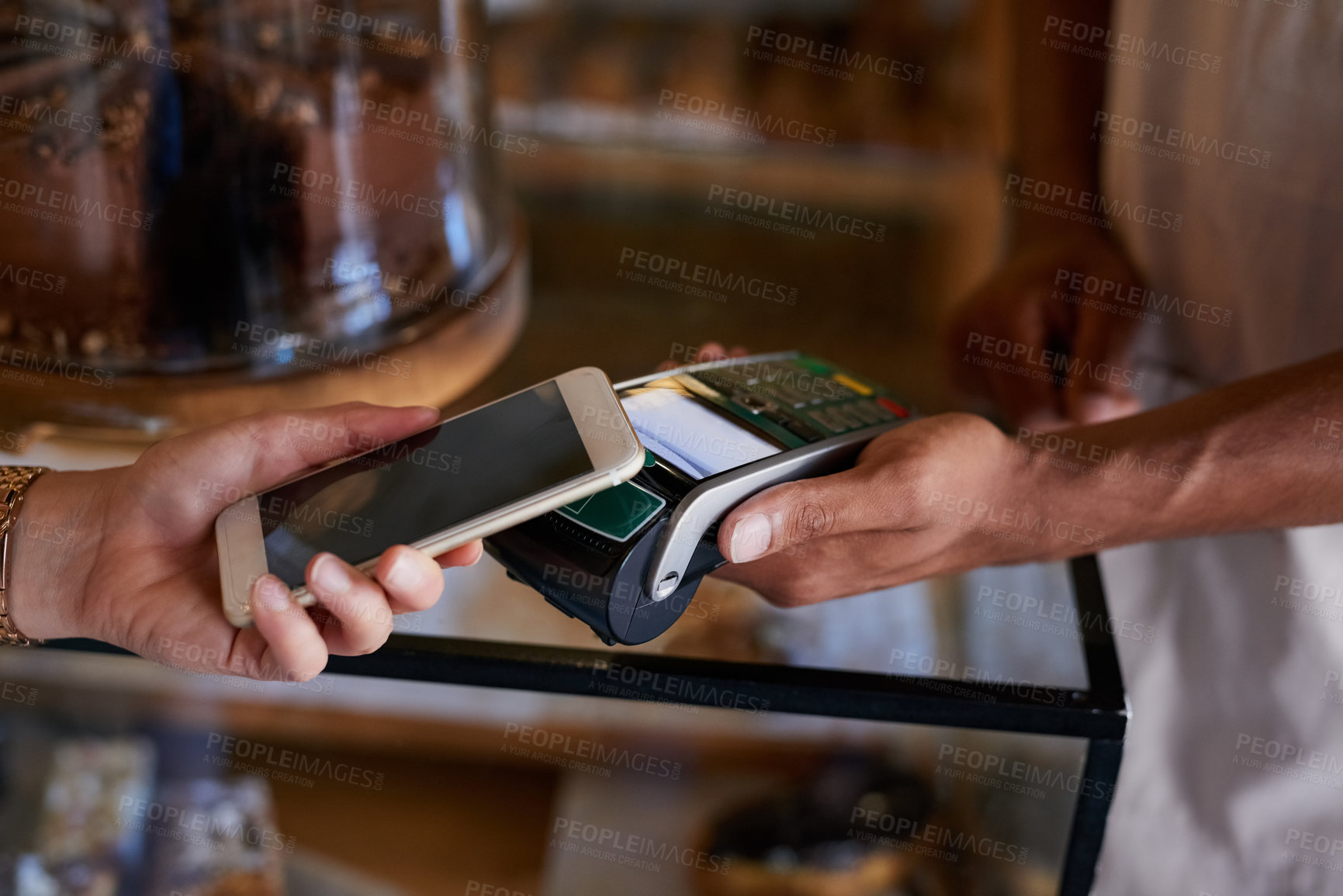 Buy stock photo Closeup shot of a customer paying using NFC technology in cafe