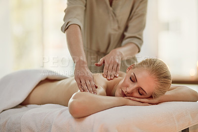 Buy stock photo Cropped shot of a young woman enjoying a back massage at a spa