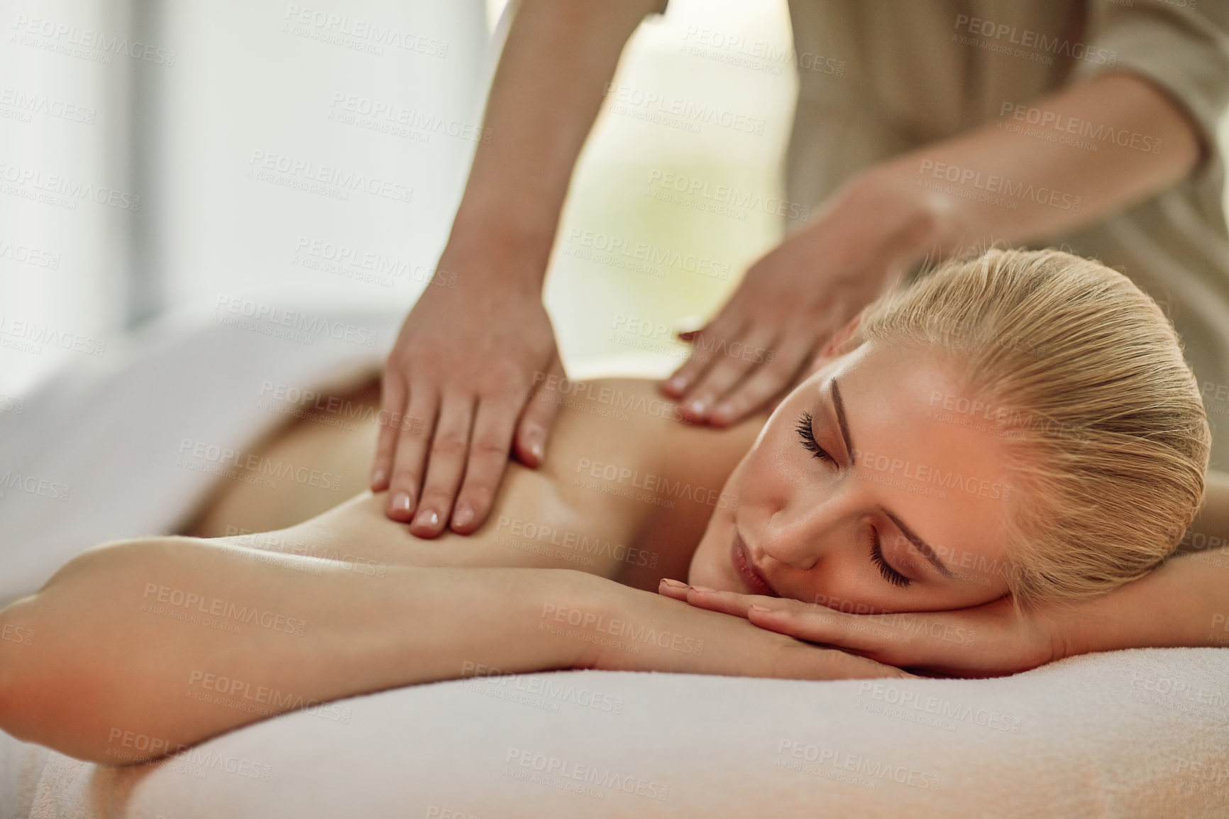 Buy stock photo Cropped shot of a young woman enjoying a back massage at a spa