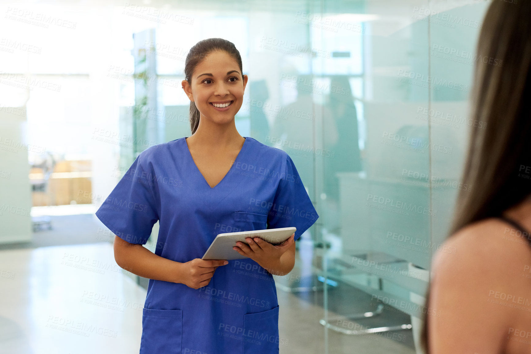 Buy stock photo Shot of a friendly young nurse greeting a patient in the clinic