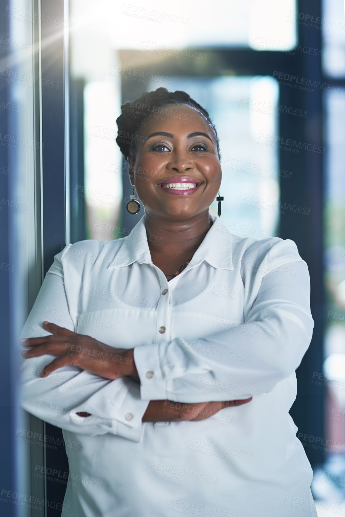 Buy stock photo Portrait of a happy businesswoman posing in the office with her arms folded