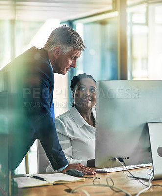 Buy stock photo Shot of two businesspeople working together at a computer in the office