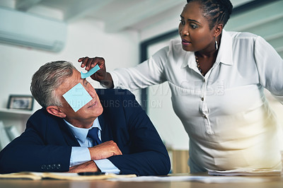 Buy stock photo Shot of a businesswoman removing adhesive notes from her coworker's eyes as he sleeps at his desk