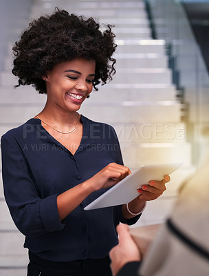Buy stock photo Shot of a happy businesswoman using a tablet while accepting a package from a courier in the office