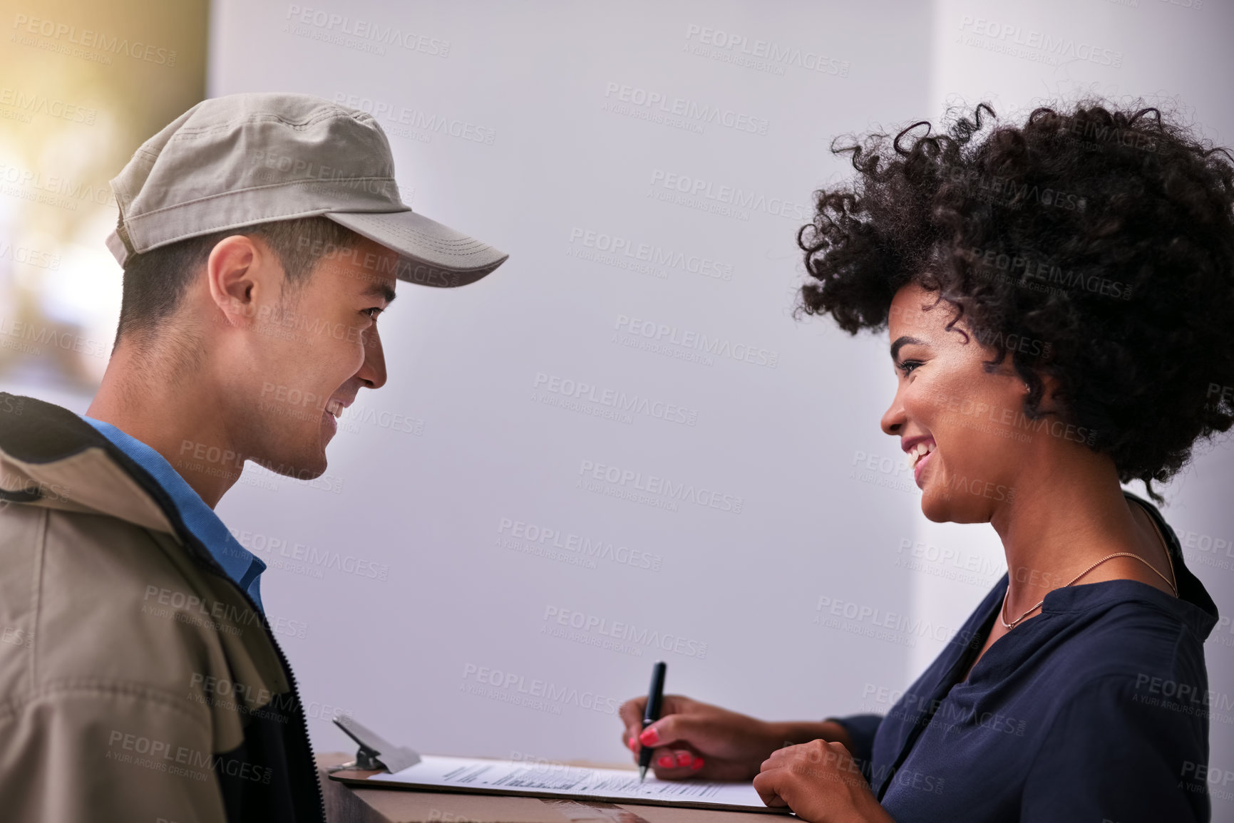 Buy stock photo Shot of a businesswoman signing for a package delivered by a courier in her office