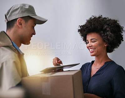 Buy stock photo Shot of a happy businesswoman using a tablet to sign for a package delivered to her office