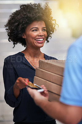 Buy stock photo Shot of a happy businesswoman accepting a pizza delivery from an unidentifiable delivery man in the office