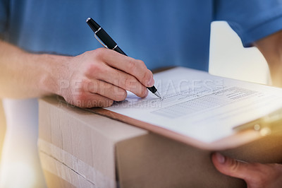 Buy stock photo Shot of an unidentifiable delivery man filling in paperwork while out on a delivery