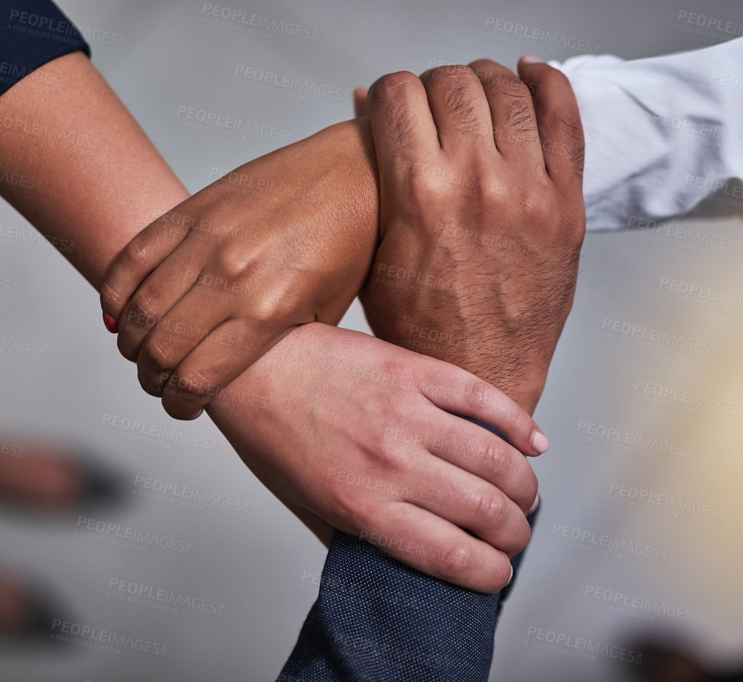 Buy stock photo High angle shot of three unidentifiable coworkers holding each other's hands in  the office
