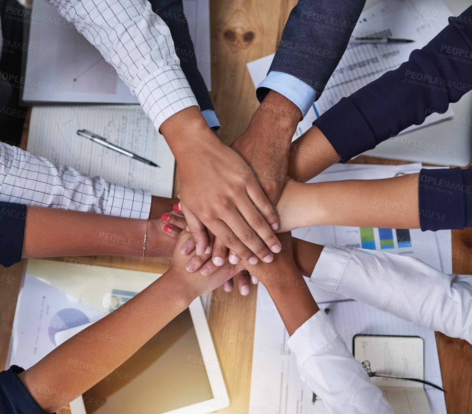 Buy stock photo High angle shot of a group of businesspeople putting their hands in a pile in the office