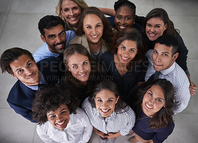 Buy stock photo High angle shot of a group of coworkers looking up while standing together in the office