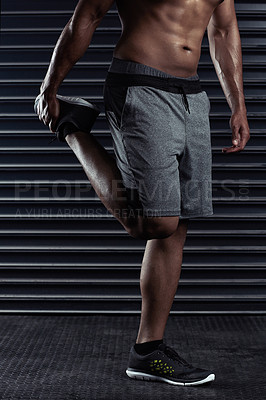 Buy stock photo Cropped shot of an unrecognizable man stretching before a workout