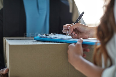 Buy stock photo Cropped shot of a woman signing for a package delivered by a courier