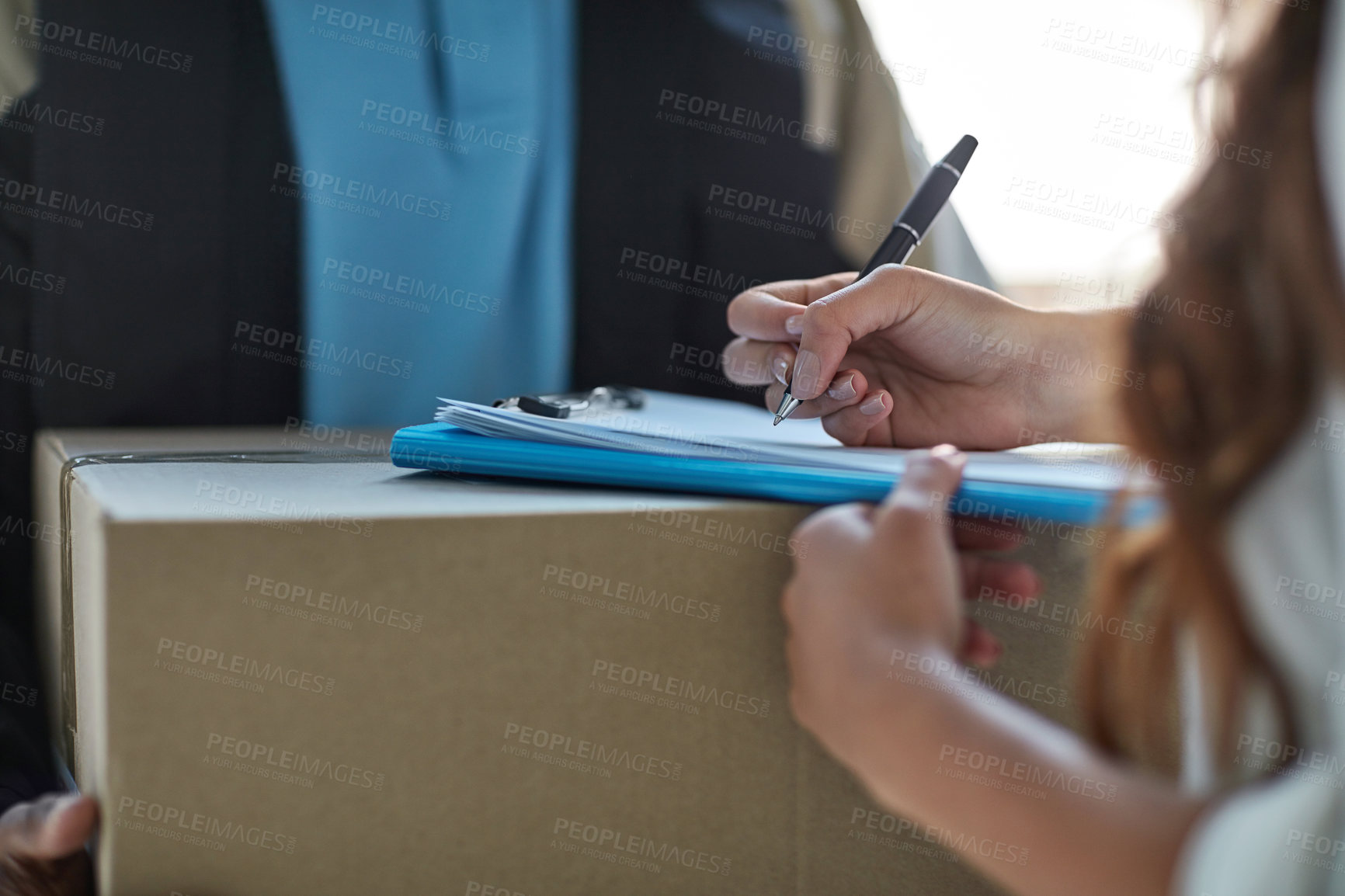 Buy stock photo Cropped shot of a woman signing for a package delivered by a courier
