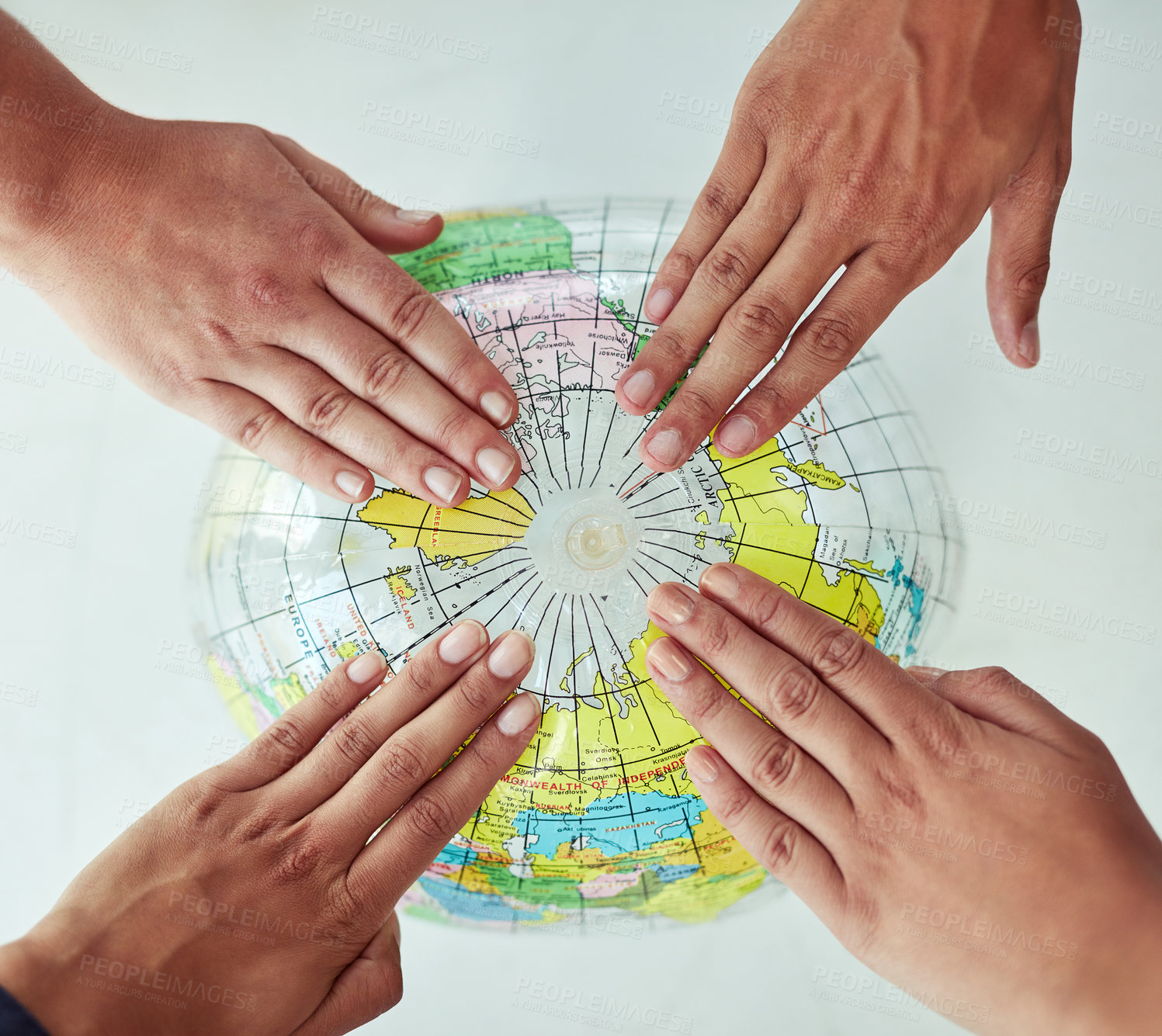 Buy stock photo High angle shot of a group of unrecognisable people with their hands on a world globe