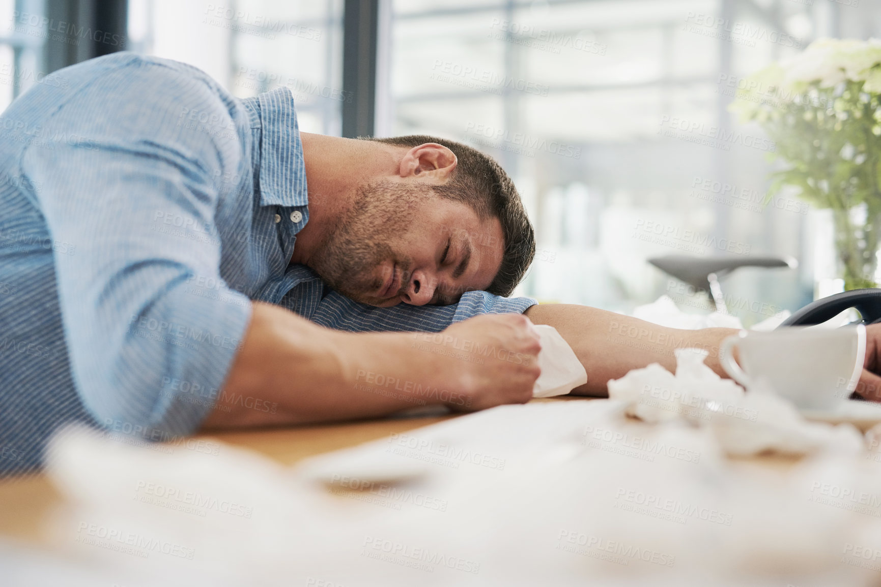 Buy stock photo Cropped shot of a tired young man with his head down on his desk