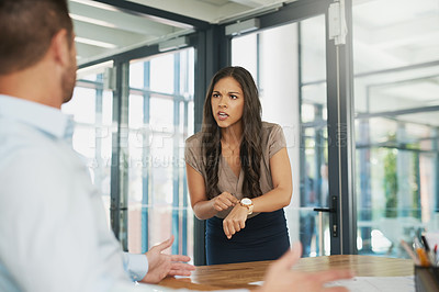 Buy stock photo Shot of an angry businesswoman scolding her colleague for being late in the office