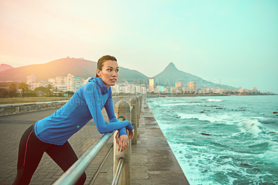 Buy stock photo Shot of a sporty young woman admiring her surroundings after a run