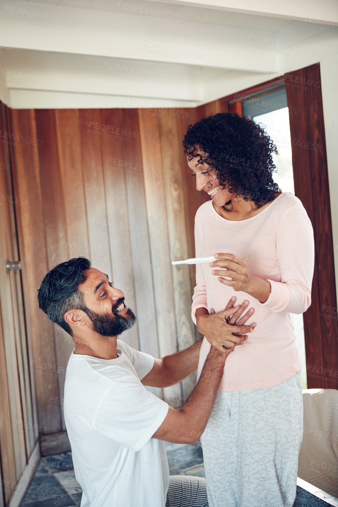 Buy stock photo Happy man, woman and pregnancy test with results, home and holding hands on stomach for congratulations. Mature couple, excited and smile for ivf success, pregnant partner and baby for celebration