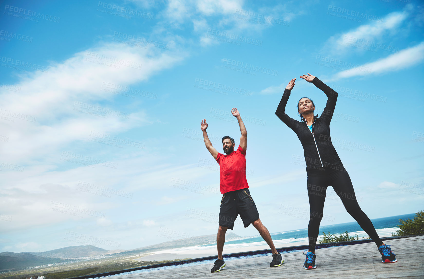 Buy stock photo Couple, stretching and arms for fitness outdoor with warm up, blue sky and morning activity for flexibility with mockup. People, exercise and teamwork for yoga by ocean with wellness, jump or active 