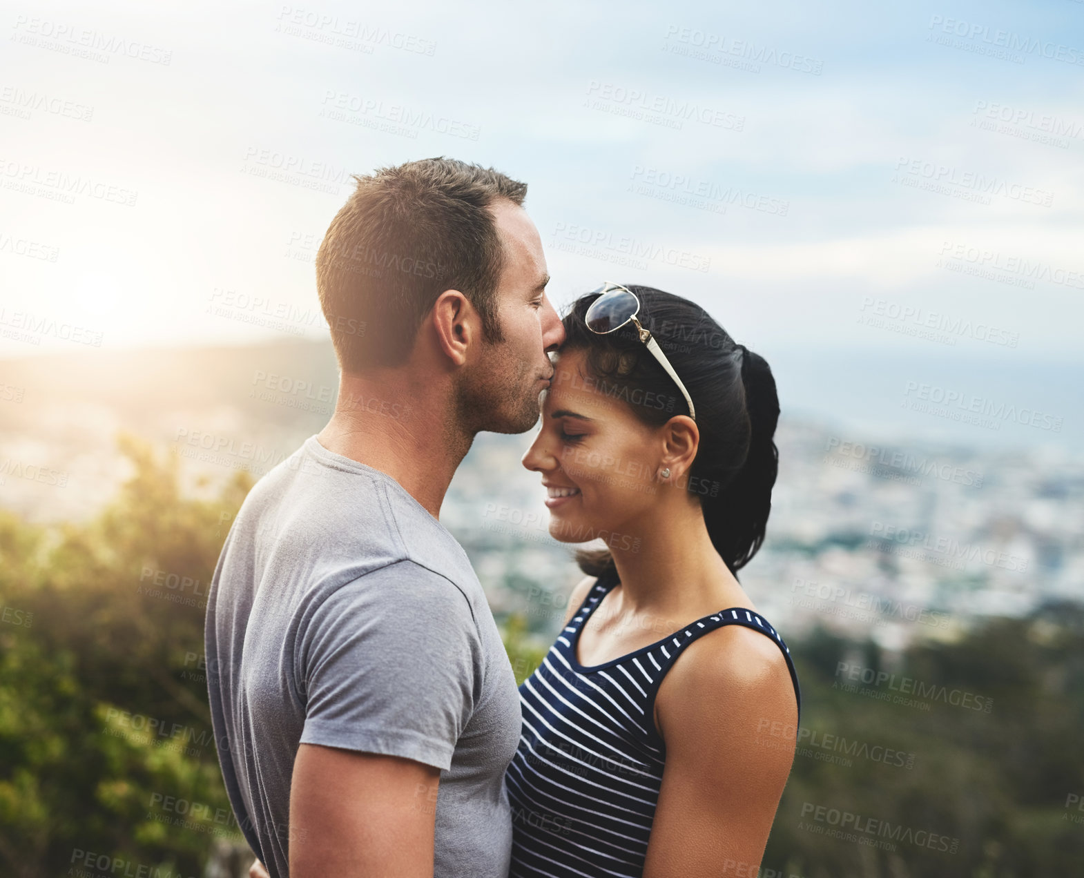 Buy stock photo Support, love or couple kiss in park for date, wellness or care on summer romance or adventure. Forehead, hug or man with happy woman on outdoor holiday vacation together for bond, travel or freedom