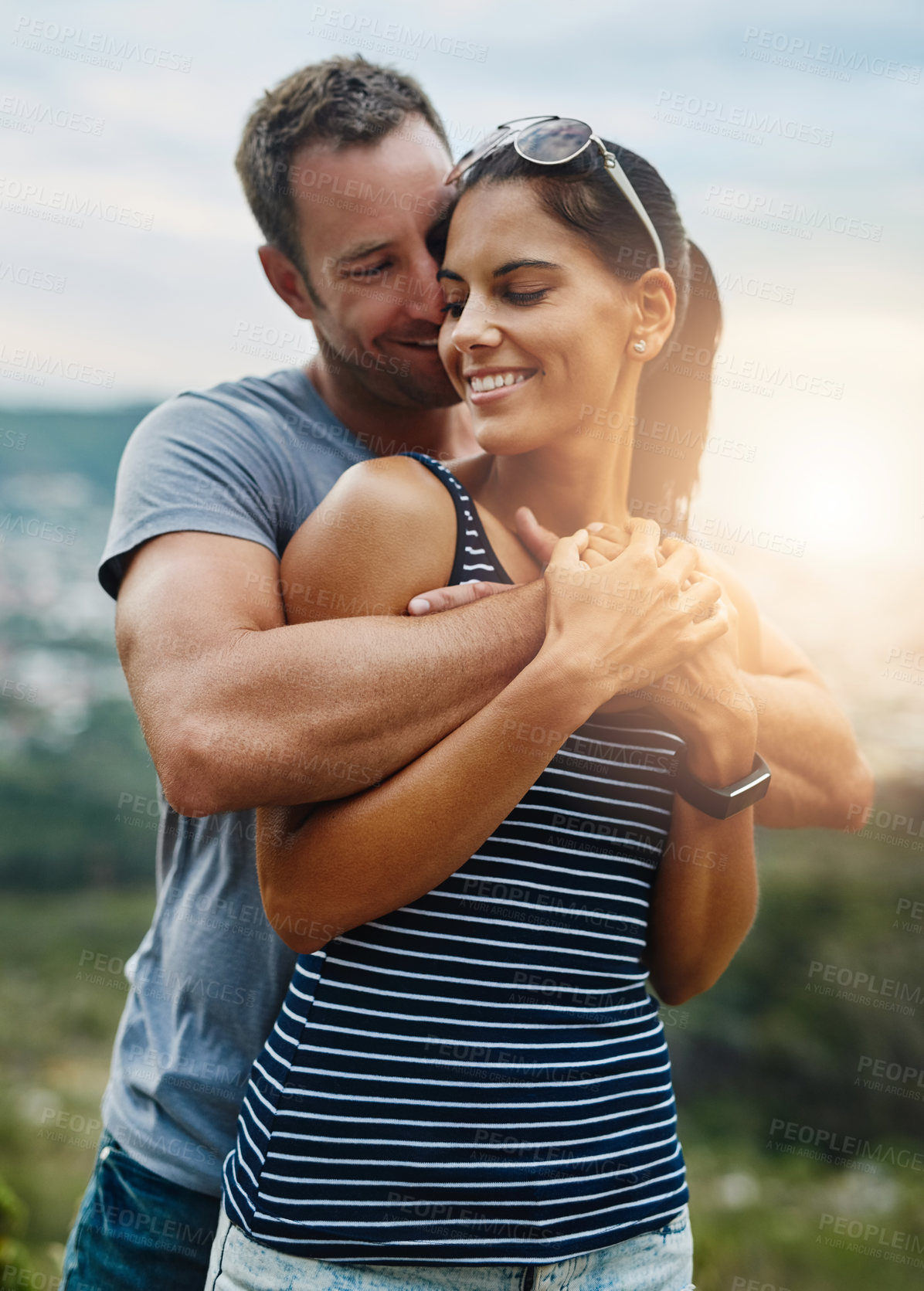 Buy stock photo Shot of a young couple in a loving embrace outdoors