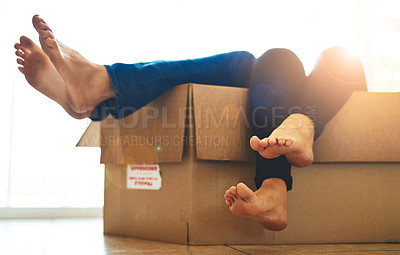 Buy stock photo Shot of an unidentifiable young couple lying in a box together with their feet sticking out
