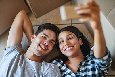 Buy stock photo Couple, selfie and floor together in home, happy and smiling or online app in apartment with love. Above, social media and internet post or update for memory, photography and bonding on ground