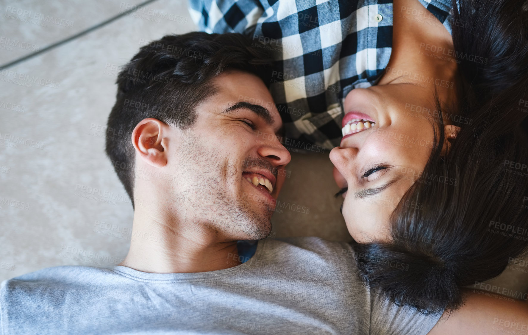 Buy stock photo Couple, talking and above on floor of home, love and laughing for funny conversation in apartment. Happy people, speaking and laying on ground of living room, support and comedy in relationship