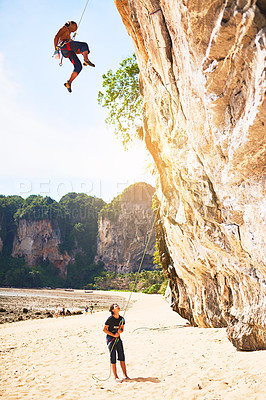 Buy stock photo Nature, rock climbing and people with rope by cliff for adventure, adrenaline or fitness challenge. Extreme sports, travel and man with instructor for harness gear for mountain activity on holiday.