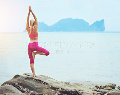 Buy stock photo Rearview shot of a young woman doing yoga on a tropical beach