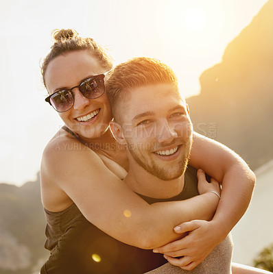 Buy stock photo Portrait of a young man giving his girlfriend a piggyback ride outside