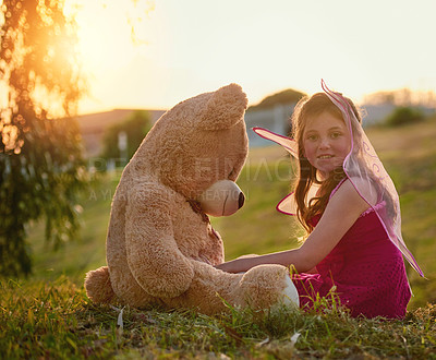 Buy stock photo Portrait of a cute little girl playing with a huge teddybear in the park