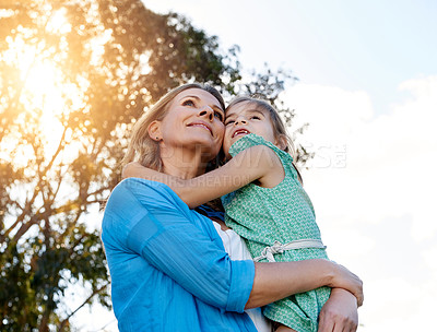 Buy stock photo Happy, family and mother holding kid in arms outdoor for bonding, time and care together in nature. Mom, young girl and smile for love embrace, hug or support outside for growth and travel on holiday