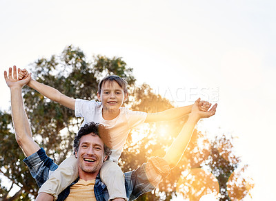 Buy stock photo Portrait of a happy father carrying his young son on his shoulders outdoors