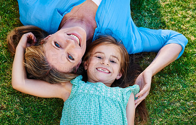 Buy stock photo High angle shot of a happy mother and daughter relaxing on the grass together outside