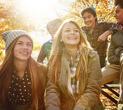 Buy stock photo Happy, teenagers and friends outdoor in park for relaxing day on summer vacation of semester break, together and talking. Group, diversity and trees in garden on holiday in New Zealand and lens flare