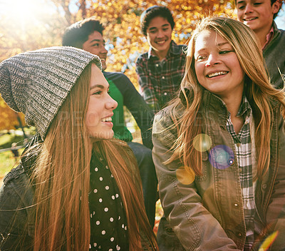 Buy stock photo Talking, happy and friends outdoor in park for relaxing day on summer vacation of semester break, together and bonding. Group, diversity and trees in garden on holiday in New Zealand and lens flare.